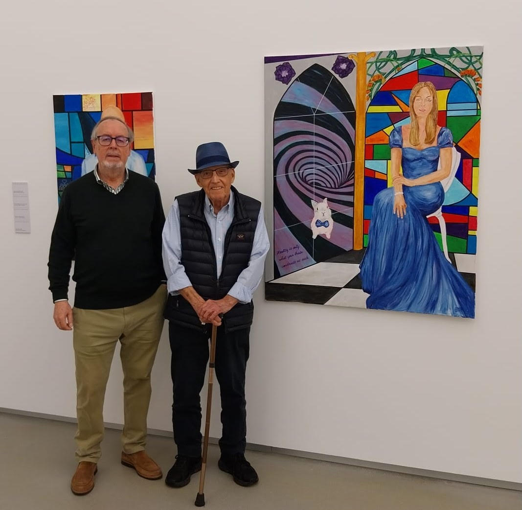 Amado Moreno junto a Roberto Moreno, posando delante de dos de los retratos expuestos en el rectorado de la Universidad de Las Palmas